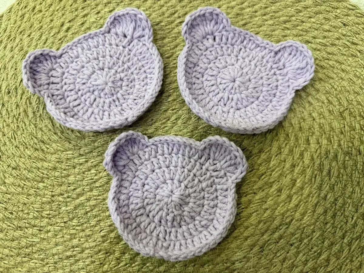 Three lilac bear-head coasters.