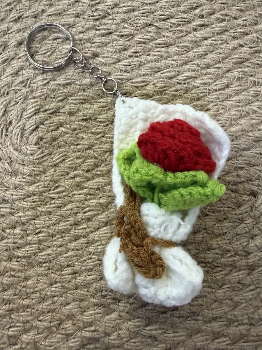 A mini crochet red rose bouquet keychain.