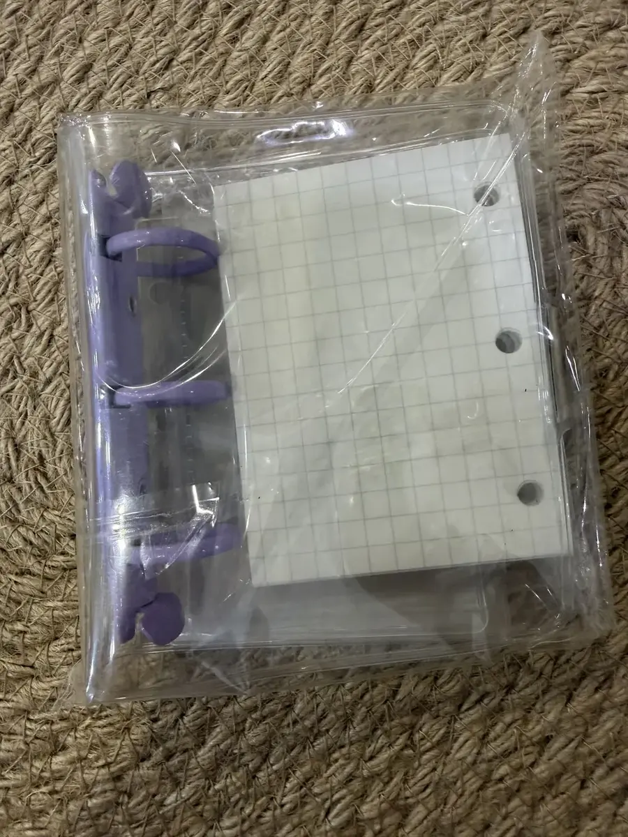 A mini purple ring-binder notebook with grid paper.